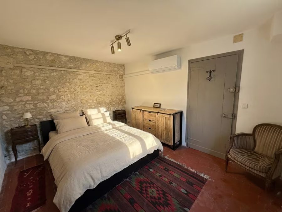 Chambre 1 du gîte, lit double et mur en pierre
